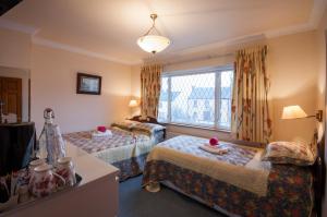 Habitación de hotel con 2 camas y ventana en Asgard Guest House, en Galway