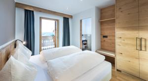 sypialnia z dwoma białymi łóżkami i oknem w obiekcie Putzerhof w mieście Siusi