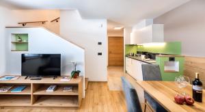 kuchnia i jadalnia ze stołem i telewizorem w obiekcie Putzerhof w mieście Siusi