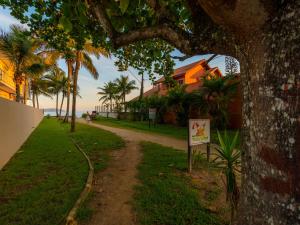 a dirt road with a sign next to a tree at Hotel Venice Ubatuba in Ubatuba