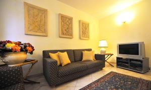 a living room with a couch and a tv at Hotel Riviera Blu in Tirrenia