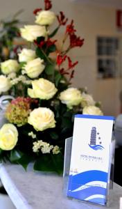 a table with a bouquet of white roses and a sign at Hotel Riviera Blu in Tirrenia