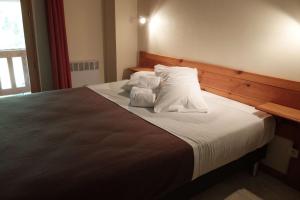 - une chambre avec un grand lit et des oreillers blancs dans l'établissement Le Mas De Roux, à Bragassargues