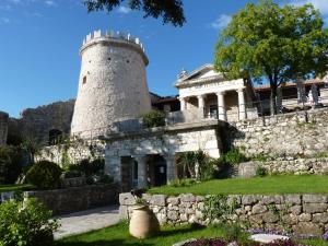 un edificio con una pared de piedra y una torre en Kappa apartments, en Rijeka