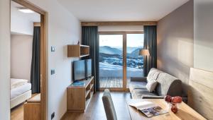 a living room with a couch and a tv at Putzerhof in Siusi