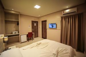 a hotel room with a bed and a tv at Hotel London Santarem in Santarém