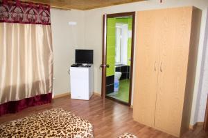 um quarto com uma cama, uma televisão e uma porta em Імобільяре em Khorostkiv