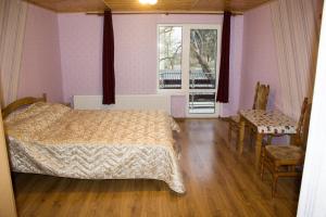 1 dormitorio con cama, ventana y silla en Імобільяре, en Khorostkiv
