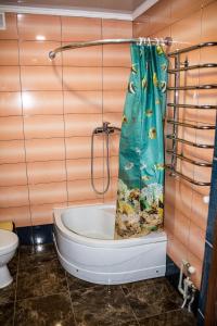 a bathroom with a bath tub with a shower curtain at Імобільяре in Khorostkiv