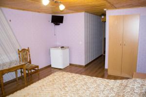 sala de estar con cama y TV en la pared en Імобільяре, en Khorostkiv