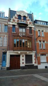 a brick building with a balcony on top of it at Maison Ulysse in Amiens