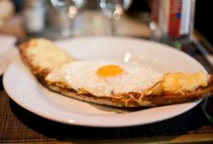 an egg on a white plate on a table at Porto Franco Residence in Brăila