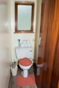 Baño pequeño con aseo y ventana en Good Times Self Catering Apartments, en Swakopmund