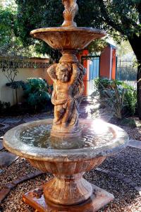 a statue of a water fountain in a garden at Rozendal Guest House in Centurion