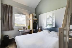 Un pat sau paturi într-o cameră la B&B HOTEL Beauvais