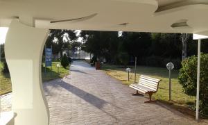 a park bench sitting on a brick walk way at Parthenis Riviera Hotel in Athens