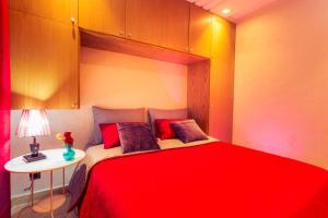 - une chambre avec un grand lit rouge et une table dans l'établissement Casablanca Home Stay Apartment, à Casablanca