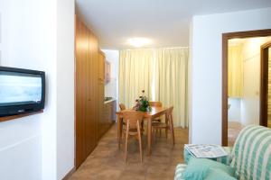 a small living room with a table and a television at Appartamenti Campo Smith in Bardonecchia