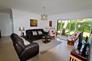 a living room with a black couch and a tv at Villa Violeta 51 - Clever Details in Vilamoura