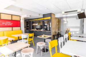 a dining room with tables and yellow chairs at B&B HOTEL Troyes Barberey in Barberey-Saint-Sulpice