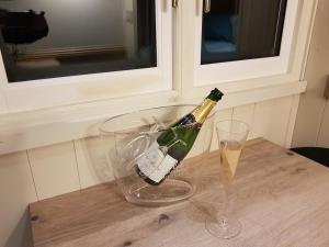 a bottle of champagne and two glasses on a table at Waterside Shepherds Hut in York