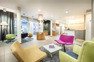 a living room with colorful chairs and a table at Hapimag Ferienwohnungen Berlin Zoo in Berlin