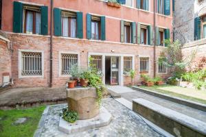 um edifício de tijolos com vasos de plantas em frente em Venice and Venice Apartments - private rooms in shared apartment em Veneza