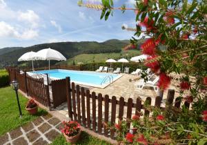 a swimming pool with umbrellas and tables and chairs at Podere di Mero Casolare in Buti
