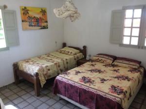 um quarto com 2 camas e 2 janelas em Casa a Beira Mar Japaratinga em Japaratinga