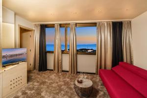 sala de estar con sofá rojo y ventana grande en The View Luxury Rooms, en Split