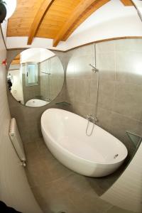 a bathroom with a white tub and a mirror at Ca l'Andreu in Ribera de Montardit