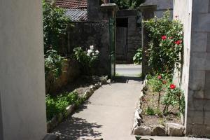 an entrance to a garden with a gate and roses at chez Huguette in Marcilhac-sur-Célé