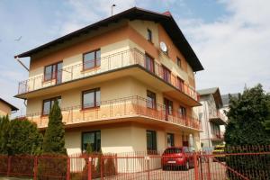 a building with a red car parked in front of it at Pokoje Gościnne U Broni in Mielno