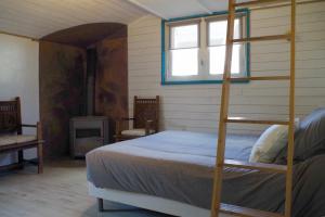 a bedroom with a bunk bed and a fireplace at Entre Mer et Marais Salants in Guérande