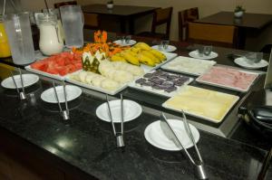 Stop Inn Plus Pampulha في بيلو هوريزونتي: طاولة مع مجموعة من الأنواع المختلفة من الطعام