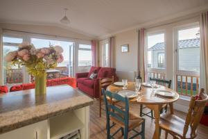 a living room with a table with a vase of flowers at Sole Bay View in Sizewell