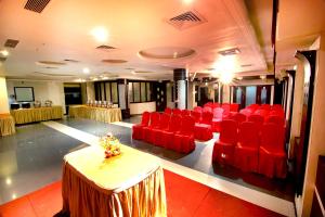 a conference room with red chairs and a table in it at Hotel Meera in Raipur