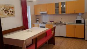a kitchen with a table and a kitchen with yellow cabinets at AS Brela in Brela
