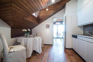 Charming and cosy apartment near Lucerne في Römerswil: مطبخ مع طاولة عليها إناء من الزهور