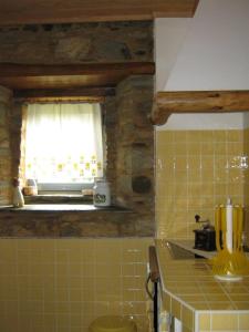 a kitchen with a window and a yellow tiled wall at Vilar dos Condes in Madeirã +14 photos