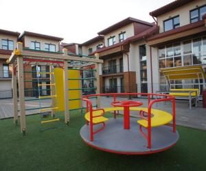a playground with a table and chairs on the grass at Malūno Vilos apartamentai centre in Palanga