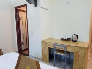 a wooden desk with a blue chair next to a bed at Trường An Hostel in Việt Trì