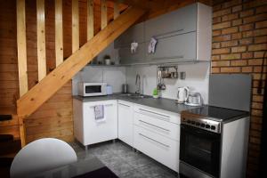 a kitchen with white appliances and a wooden ceiling at Velence Korzó Pihenőház in Kápolnásnyék