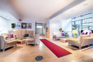 a living room with couches and chairs and a red rug at Hapimag Berlin Gendarmenmarkt in Berlin