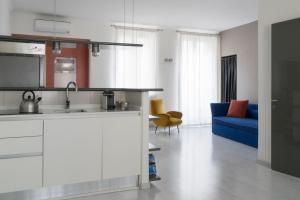 a kitchen and a living room with a blue couch at Brera Apartments in Milan