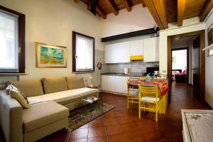 een woonkamer met een bank en een tafel en een keuken bij Holiday Treviso Suite LOMBARDI in Treviso