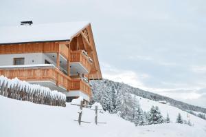 um edifício no topo de uma montanha coberta de neve em Apartments Oberpichlhof em Valdaora