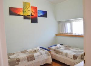 モンテ・イーゾラにあるAppartamento Bella Isolaの壁に絵画が飾られた客室内のベッド2台