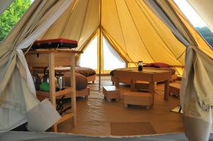 a tent with a bed and a table in it at Ecodomaine Chemins de Traverse in Auberive