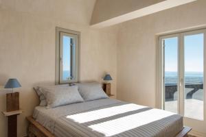 a bedroom with a bed with a view of the ocean at Amaranthine Villa in Imerovigli +38 photos